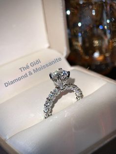 a diamond ring sitting in a box on top of a white surface with the words, the gidi diamond & moissatite