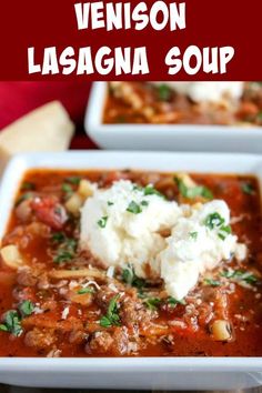 two white bowls filled with lasagna soup on top of a red tablecloth