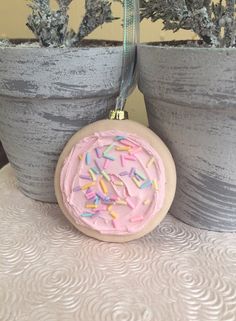 two potted plants with pink frosting and sprinkles hanging from them