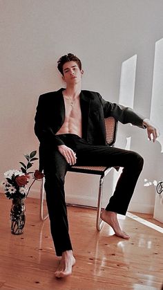 a man sitting in a chair with his shirt off