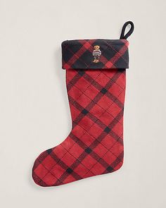 a red and black plaid christmas stocking hanging on a wall