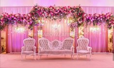 an elaborately decorated stage set with pink flowers and chandeliers on the wall