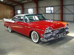 an old red car parked in a garage