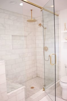 a white toilet sitting next to a walk in shower