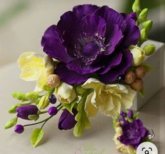 purple and yellow flowers are sitting on a table