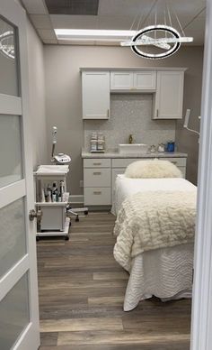 a room with a bed, sink and cabinets in it