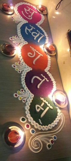 a decorated table with candles on it and the words happy diwali written in different languages