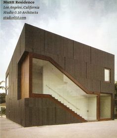 a modern house with stairs leading up to the second floor and windows on the upper level