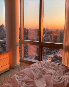 a bedroom with a large window overlooking the city