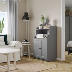 a living room with a white couch and grey cabinet