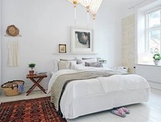 a bedroom with white walls and flooring has a rug on the floor