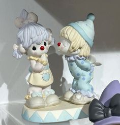 two little figurines are standing next to each other