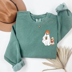 Get cozy this spooky season with our Comfort Colors® Cute Ghost Dog Sweatshirt! Perfect for dog lovers, this Halloween Dog Sweatshirt features an adorable ghost dog design that's sure to bring a smile. Whether you're sipping coffee or enjoying a crisp autumn day, this Ghost Coffee Sweatshirt is the perfect fall crewneck. It's also a thoughtful Dog Lover Halloween Gift for anyone who loves their furry friend as much as they love Halloween. Stay warm and stylish this fall with this charming sweatshirt! Please review the size chart before buying a product. Select your shirt color using the following drop-down menu. Note that all sizes are UNISEX - check the Size Chart in Listing Photos The position, colors, and size of the prints may differ slightly from the illustrations. - We recommend turn Halloween Embroidery Sweatshirt, Cute Halloween Crewneck, Cute Cotton Halloween Sweatshirt, Halloween Embroidered Cotton Sweatshirt, Embroidered Ghost Sweatshirt, Dog Halloween Sweatshirt, Ghost Coffee, Fall Crewneck, Sipping Coffee