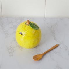 an orange sitting on top of a counter next to a wooden spoon