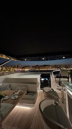 the interior of a boat at night, with lights on and furniture in the foreground