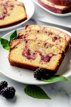 slices of cake on plates with berries and leaves