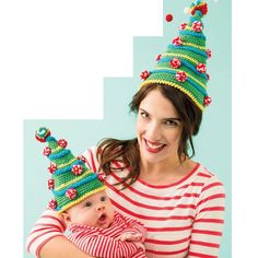 a woman holding a baby wearing knitted hats