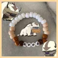 the beaded bracelet is decorated with an appa dog and two small beads on it