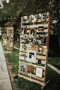 a wooden sign with pictures on it sitting in the grass