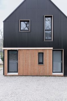 a black house with wooden siding and windows