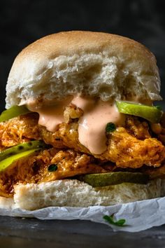 a chicken sandwich with pickles and ranch dressing