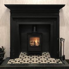 a fireplace with a black mantle and tiled floor