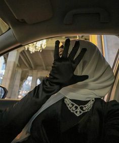 a woman in black and white is sitting in a car