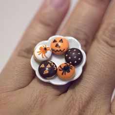 a person's hand holding a ring decorated with halloween decorations