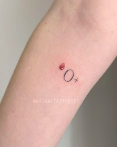 a person with a small tattoo on their arm that reads q and has an o