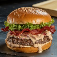 a hamburger with bacon, lettuce and cheese