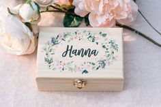 a wooden box with the word mama written on it next to flowers and greenery