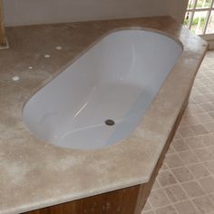 a white sink sitting on top of a counter next to a tiled floor and window