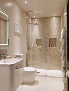 a bathroom with a toilet, sink and shower stall is pictured in this image from the front view