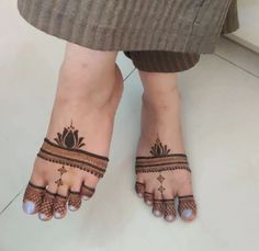 a woman's feet with henna tattoos on them