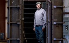 a man standing in front of a metal door