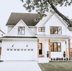 a large white house with two story windows and black shutters on the front door