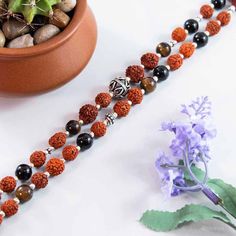 Just like physical core strength, our spiritual core strength is of vital importance for our growth and well being. The Core Strength mala is designed to guide you towards developing a strong spiritual center and provides the strength, endurance and guidance that enables you to face life's toughest challenges with calmness. This is a powerfully strong 108 beads mala featuring Rudraksha paired with Black Onyx, Tiger Eye and Sterling Silver mantra beads. Core Strength will prove to be the cornerst Traditional Mala With Natural Stones For Meditation, Spiritual Gemstone Beads For Rituals, Holistic Healing Beads For Festivals, Spiritual Mala With Polished Beads For Healing, Spiritual Healing Mala With Polished Beads, Spiritual Polished Beads For Meditation, Spiritual Mala With Round Beads For Yoga, Spiritual Mala For Yoga With Round Beads, Spiritual Yoga Mala With Round Beads