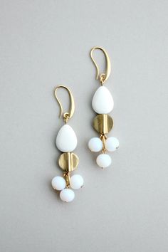 18k gold plated brass hook earrings with glass and brass. Each earring weighs .18 oz and measures 2.75 inches. Nickel-free Glass Drop Earrings, Elegant Glass Beaded Drop Earrings, White Brass Dangle Earrings, Nickel-free Glass Dangle Earrings, Nickel-free Dangle Glass Earrings, White Czech Glass Dangle Earrings, Elegant Glass Dangle Earrings, White Glass Earrings With Ear Wire, Adjustable Gold-tone Drop Earrings