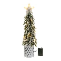 a small christmas tree in a white pot with lights on it and a black box next to it