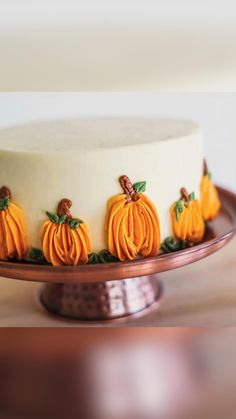 a white cake with yellow pumpkins on it and the words instagram written below