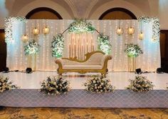 a decorated stage with white flowers and greenery