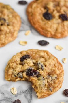 cookies with oats and raisins are on a marble surface, one is broken in half