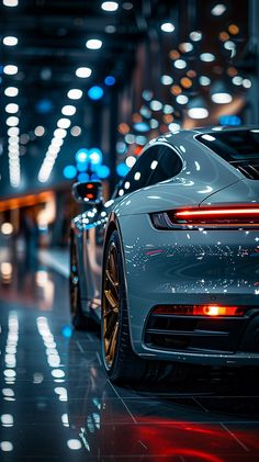 the back end of a white sports car parked in a parking lot at night time