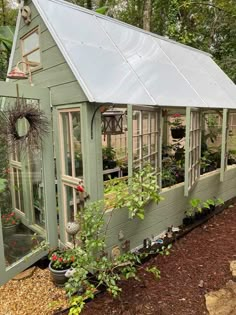 a small green house with lots of plants in it