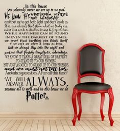 a wall decal with the words harry potter written in black on it and a red chair next to it