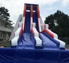 an inflatable water slide that is blue and white with red piping on it