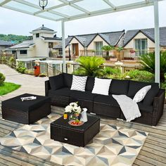 an outdoor living area with black furniture and white pillows