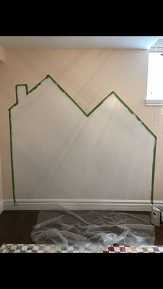 a room that has been painted with green tape and some paint on the wall behind it