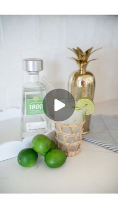 limes are sitting on the counter next to bottles