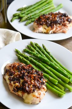 two white plates topped with chicken and asparagus